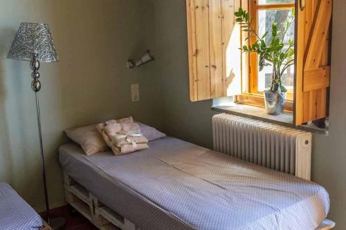 迈萨纳''Arsinoe'' cosy guesthouse的一间卧室配有一张带灯和窗户的床