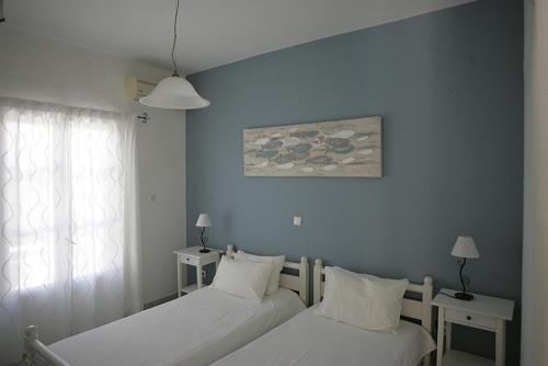 纳乌萨索菲别墅酒店的一间卧室设有两张床和一扇带绘画的窗户。