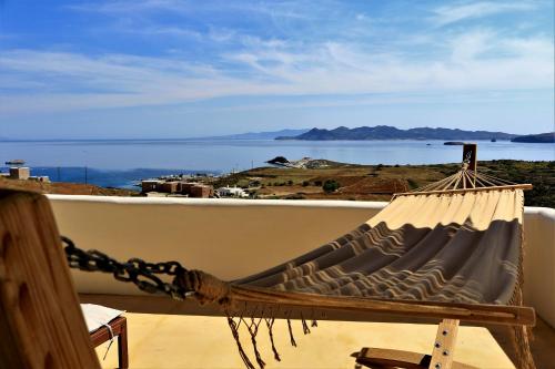 Mandrakia爱琴海蓝色度假屋的海景阳台上的吊床