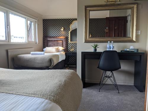 戈尔韦阿黛尔宾馆的一间卧室配有两张床、镜子和椅子
