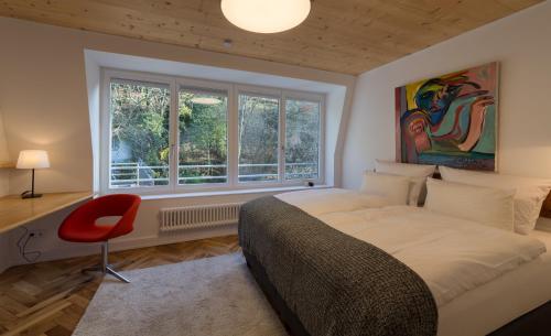 海德堡海德堡兹维特故乡酒店的一间卧室设有床、窗户和红色椅子