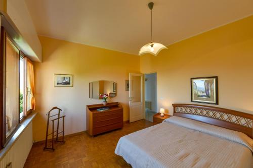 韦尔巴尼亚Villetta autonoma affacciata sul Golfo Borromeo的一间卧室配有一张床、梳妆台和镜子