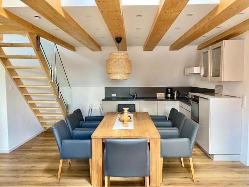 齐恩多夫Apartments bei Playmobil 2,130 m2,24h self Check-in,Free parking的厨房以及带木桌和蓝色椅子的用餐室。