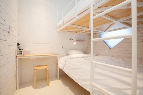 济州市米尔旅舍的一间小卧室,配有双层床和书桌