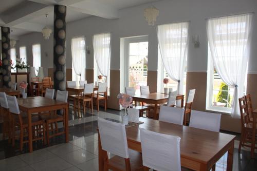 达布基Villa Happy Rose的用餐室配有木桌和白色椅子