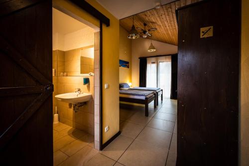 马尔Roadcamp - American Motel & Sportsbar的一间带水槽的浴室和一间带床的房间