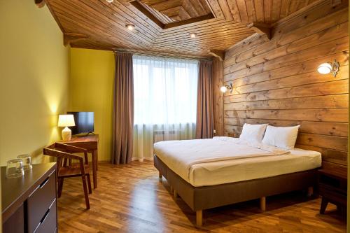 SenitsaФальварак KUPALA的一间卧室设有一张床和木墙