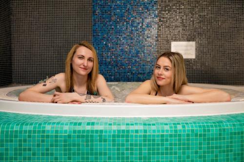 埃尔布隆格麦恩水上Spa酒店的两个女人坐在浴缸里