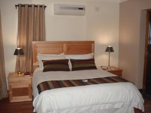 逊邱伦优伊特希格帕克旅客@home4U酒店的一间卧室配有一张带两盏灯的大型白色床。