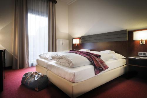 威斯巴登Hotel de France Wiesbaden City的酒店客房带一张大床,带白色床单
