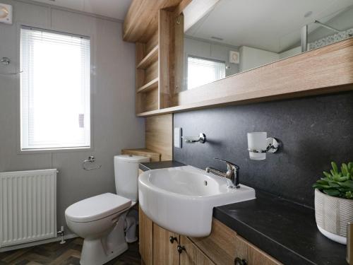 雷德鲁斯Pinehurst Lodge的浴室配有白色水槽和卫生间。
