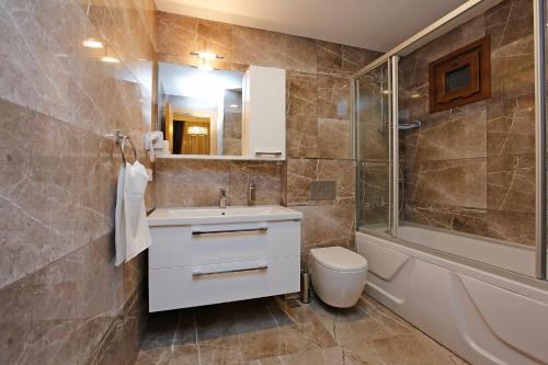 伊斯坦布尔加拉塔新艺术风格酒店的浴室配有盥洗盆、卫生间和浴缸。