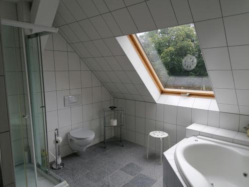 克勒珀林Schloß Wichmannsdorf的一间带卫生间和浴缸的浴室以及窗户。
