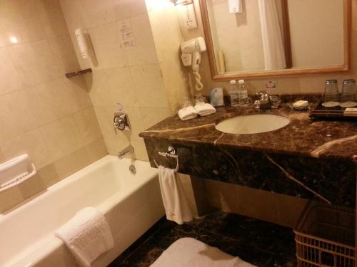 青岛青岛泛海名人酒店的浴室配有盥洗盆和浴缸。