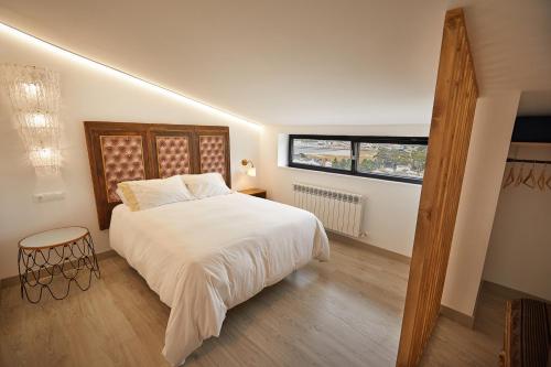 比韦罗Ático con maravillosas vistas的卧室配有白色的床和窗户。
