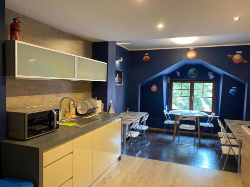 格但斯克Hostel Galaxy的厨房设有蓝色的墙壁和带微波炉的桌子。