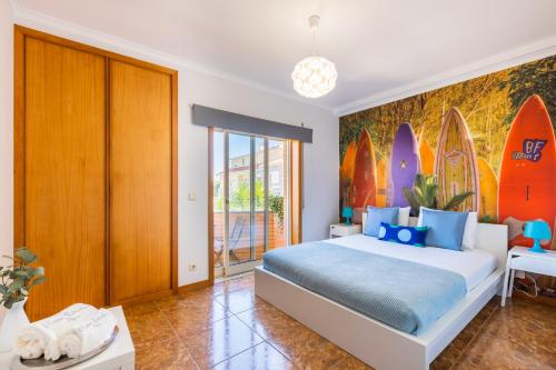 ArcozeloAguda Beach Apartment的一间卧室设有一张大床,墙上设有冲浪板