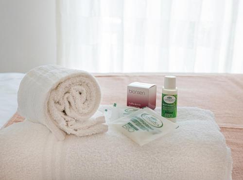 拉戈内格罗Bed And Breakfast - Lulugiù的床上的一大堆毛巾和一卷卫生纸