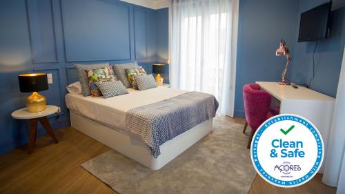 普拉亚达维多利亚ZIGZAG HOSTEL的一间卧室配有一张蓝色墙壁的床和电视
