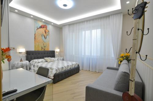 卡塞塔CASERTA DELUXE BIS的一间卧室配有一张床和一个沙发