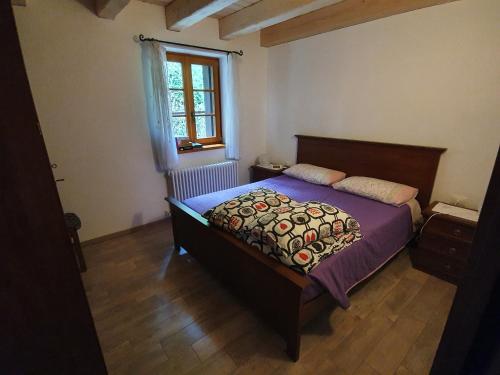 CerciventoBuine Tiere的一间卧室配有一张带紫色床单的床和窗户。