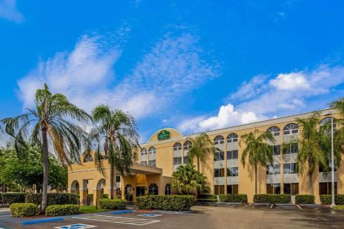 迈阿密湖迈阿密湖拉金塔旅馆及套房的停车场内棕榈树的大型建筑