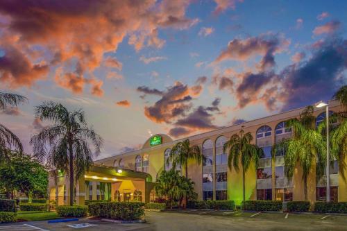 迈阿密湖迈阿密湖拉金塔旅馆及套房的日落前有棕榈树的建筑