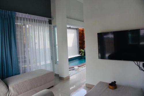 华欣Origin hua hin poolvilla的客厅配有平面电视和沙发。