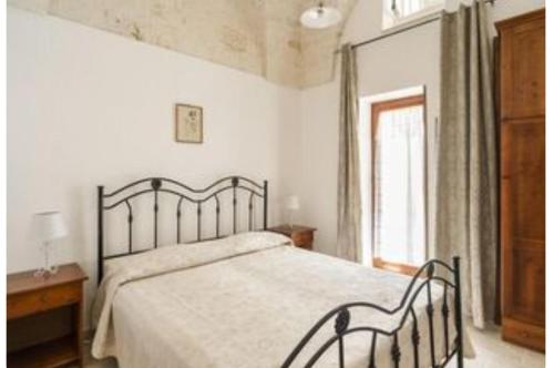 奥斯图尼Appartamento Nonna Rosa的一间卧室设有一张大床和一个窗户。