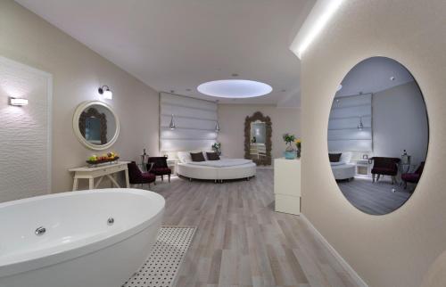海法Garden Events hotel גארדן הוטל אירועים的一间带浴缸和水槽的浴室以及一间客房。