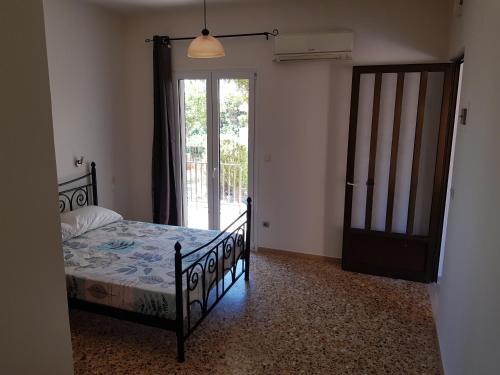 凯法利尼亚岛Filippos Apartments "Apartment 1"的一间卧室设有一张床和一个滑动玻璃门