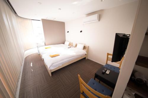 洲本市城市海月酒店的小房间设有床和电视