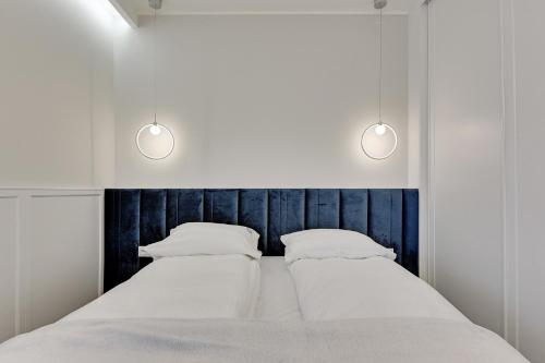 索波特Grand Apartments - Indygo Okrzei Residence Sopot的床上有2个枕头,上面有2盏灯