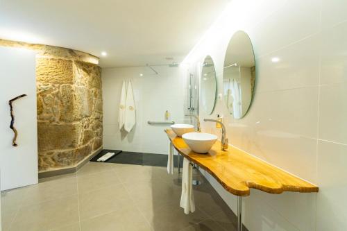 贡多马尔GOLDNATURE的一间带两个水槽和石墙的浴室
