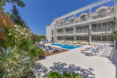 马卡尔斯卡奥斯亚法酒店的酒店拥有游泳池和躺椅