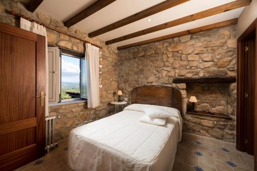 费雷拉Aldeade的一间卧室设有一张床和石墙