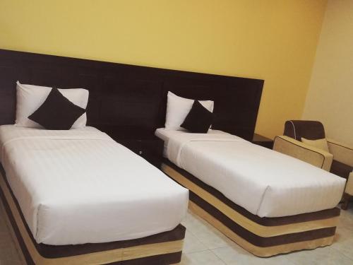 阿尔布亚米Alsafa Hotel的两张睡床彼此相邻,位于一个房间里