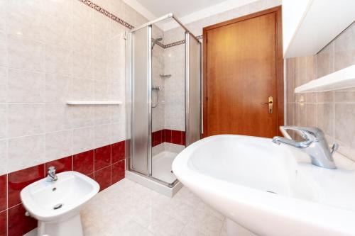 利尼亚诺萨比亚多罗Appartamenti Lignano Sabbiadoro - Villa Ammiraglia的一间带水槽、卫生间和淋浴的浴室