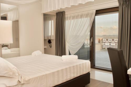 拉戈堡Hotel Boutique Castiglione del Lago的一间白色卧室,配有床和阳台