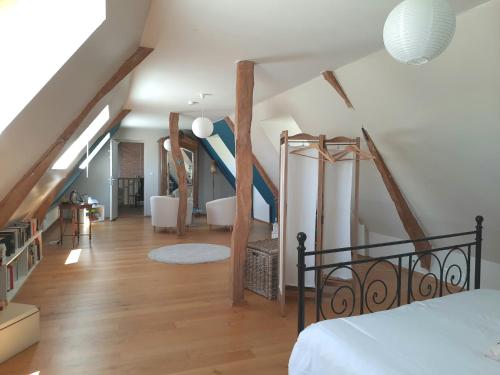 布雷特维尔迪格朗科Les Hortensias-chambre chez l'habitant的阁楼卧室设有楼梯和床。