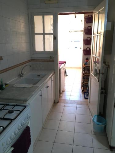 Boumhel El BassatineBelaire host appartment的白色的厨房设有水槽和炉灶。