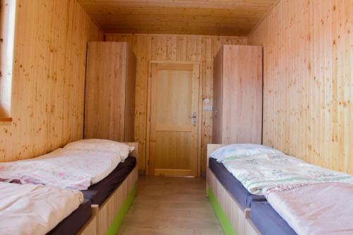 OrlíkChaty U Cvrků的木墙客房的两张床