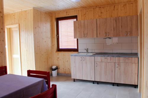 OrlíkChaty U Cvrků的厨房配有木制橱柜、水槽和桌子