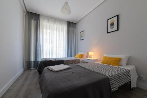 洛格罗尼奥Apartamento el centro的酒店客房设有两张床和窗户。