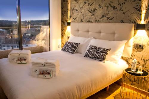 桑亨霍LaPerla Premium的一间卧室配有一张大床和毛巾