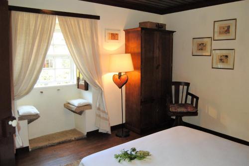 塞洛里库迪巴什图Casa de Cerqueda的一间卧室配有床、灯和窗户