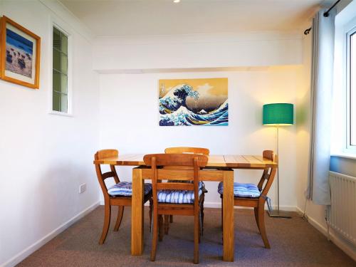 布莱顿霍夫Marina living with parking, balcony, quiet and secure的餐桌和椅子,墙上有绘画作品