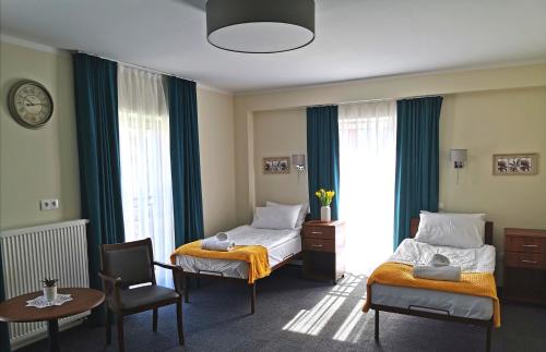 格鲁德柴兹Hotel Przy Solankach的酒店客房带两张床和一张桌子以及椅子。