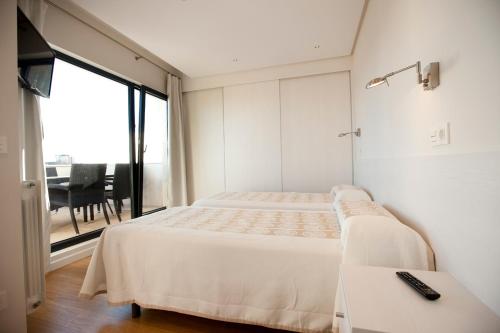 索托德拉马里纳破碎海岸公寓酒店的一间卧室设有两张床、一张桌子和一个窗口