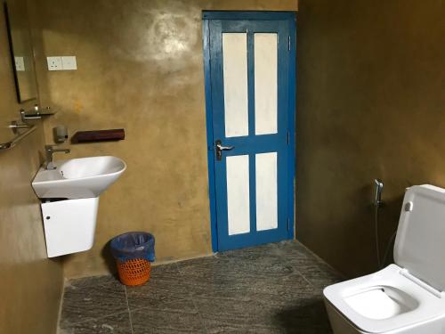 卡卢特勒静语壳民宿的浴室设有蓝色门和水槽